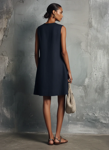 Miniabito da donna, stile professionale minimalista, scollo rotondo, bottoni asimmetrici, tasca laterale, senza maniche.